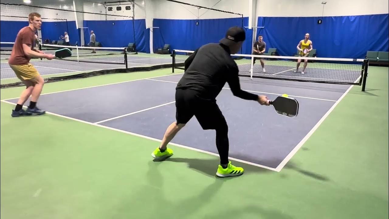 Players returning a shot during doubles at E.H.